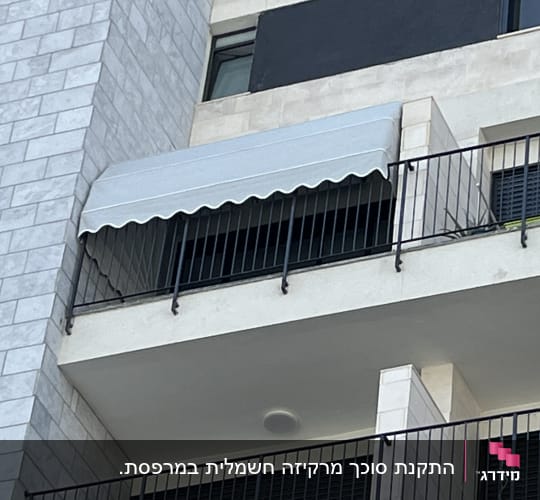 סוכך לבן על מרפסת עם מעקה ברזל